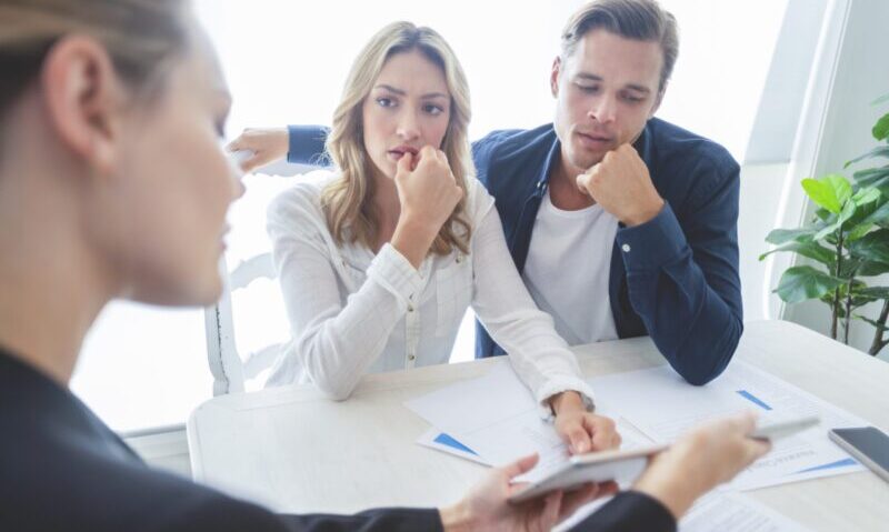 Insurance agent with couple looking through documents. Insurance agent with couple looking through documents.